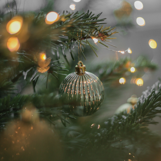 Foto af juletræ med glaskugle og lys