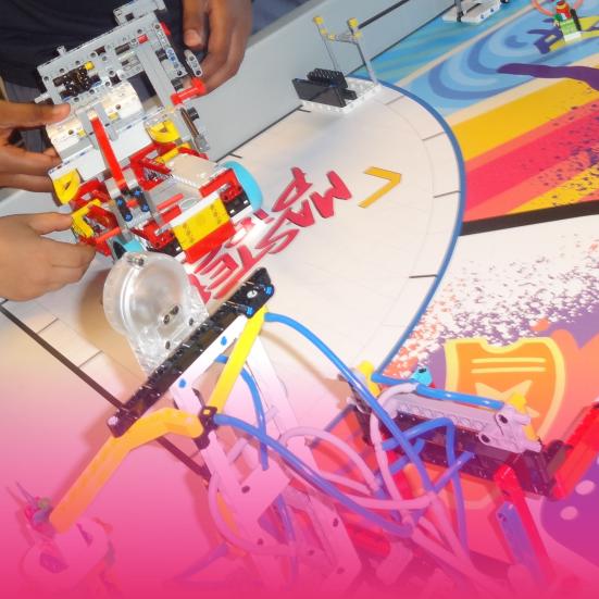 Børnehænder der holder en robot lavet ud af Lego