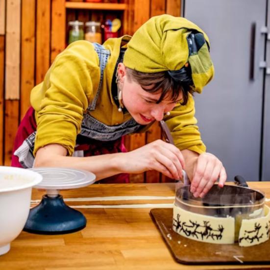 Deltager fra bageprogrammet 2026 arbejder koncentreret med en kage.
