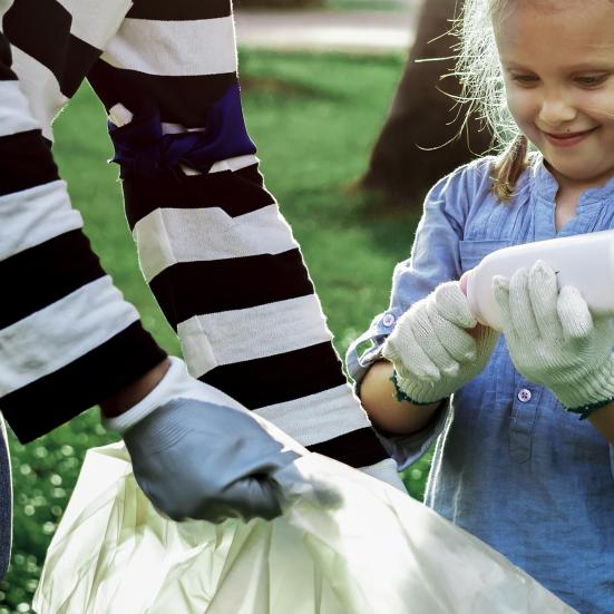 Pige og dame samler skrald i stor sæk