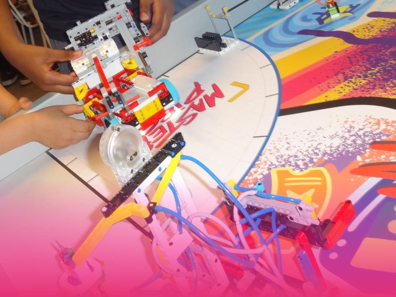 Børnehænder der holder en robot lavet ud af Lego