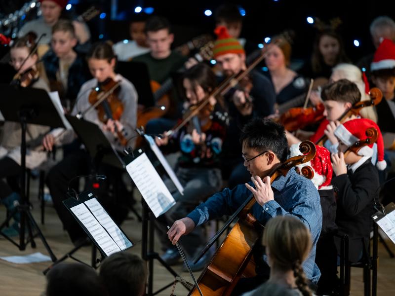 Et orkester med strygere og nissehuer på hovederne. 