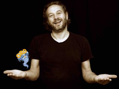 En mand står på en mørk baggrund og fortæller.