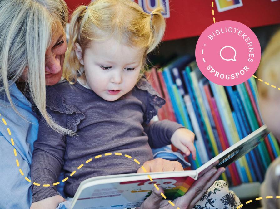 En voksen læser højt for et lille barn, der sidder på skødet af den voksne