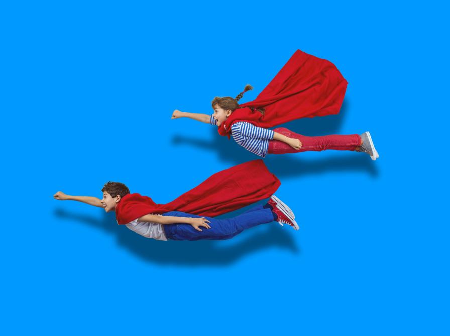 To børn i superheltekostumer flyver på en blå baggrund. 